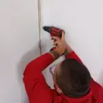Técnico de [Nombre de tu Empresa] aplicando tratamiento inyectado para termitas de madera seca.